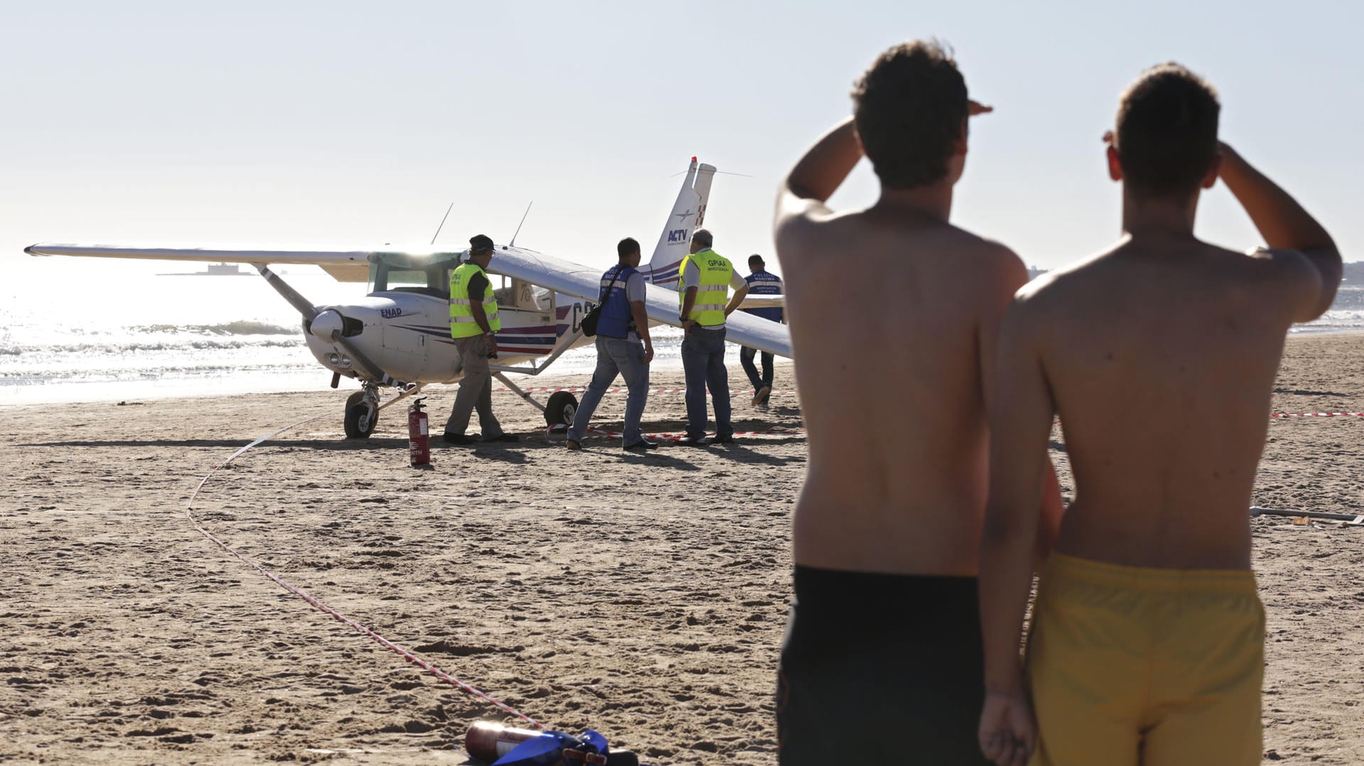 Urlauber schauen am Strand von São João da Caparica auf das Kleinflugzeug, das bei einer Notlandung zwei Menschen in den Tod riss. Urlauber schauen am Strand von São João da Caparica auf das Kleinflugzeug, das bei einer Notlandung zwei Menschen in den Tod riss.