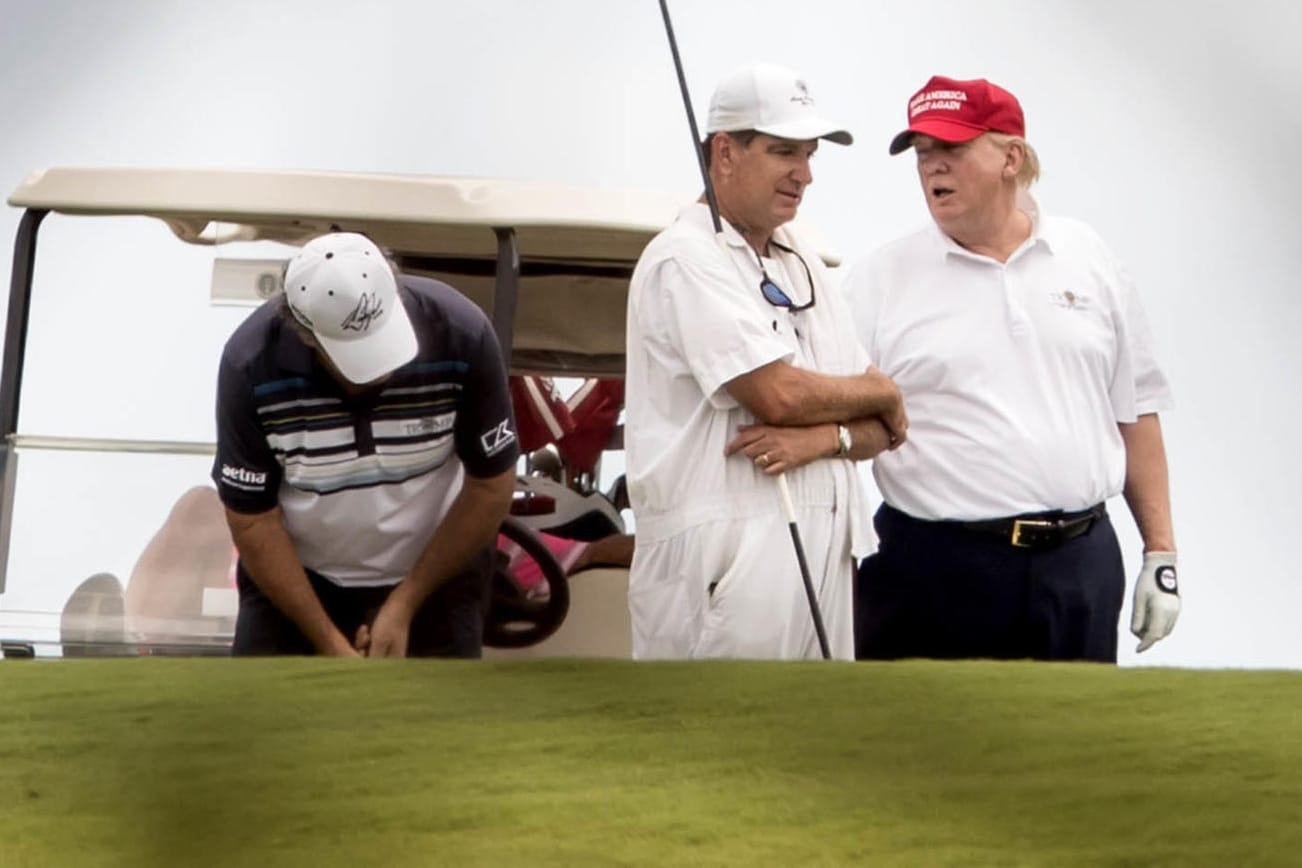 US-Präsident Donald Trump unterhält sich während einer Runde Golf auf dem Trump International Golf Club in West Palm Beach mit einem Caddie.