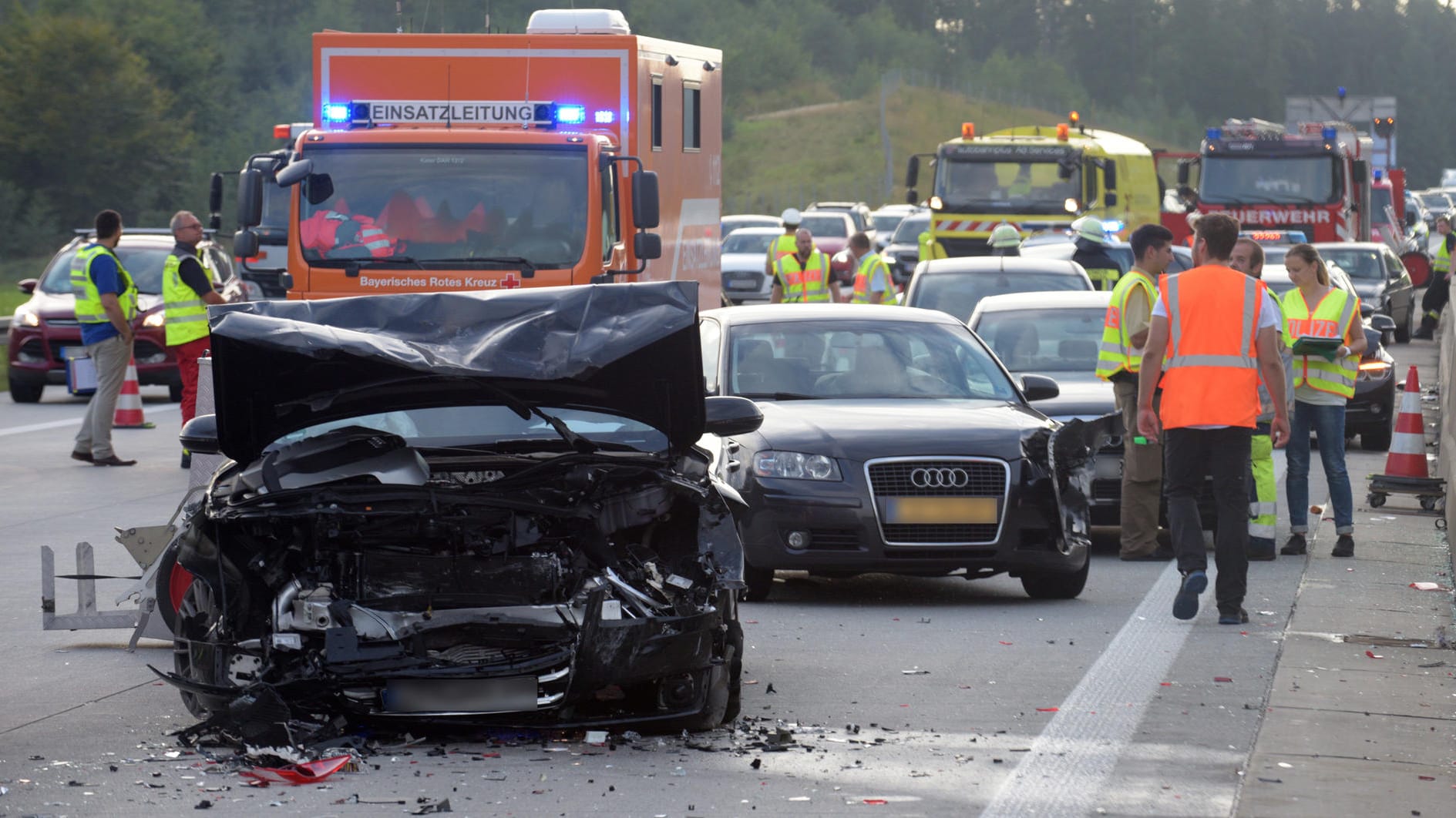 Mehrere beschädigte Autos stehen auf der Autobahn 8 auf der Fahrbahn.