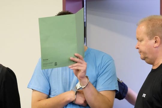 Der Angeklagte wird vor der Urteilsverkündung in den Gerichtssaal geführt.