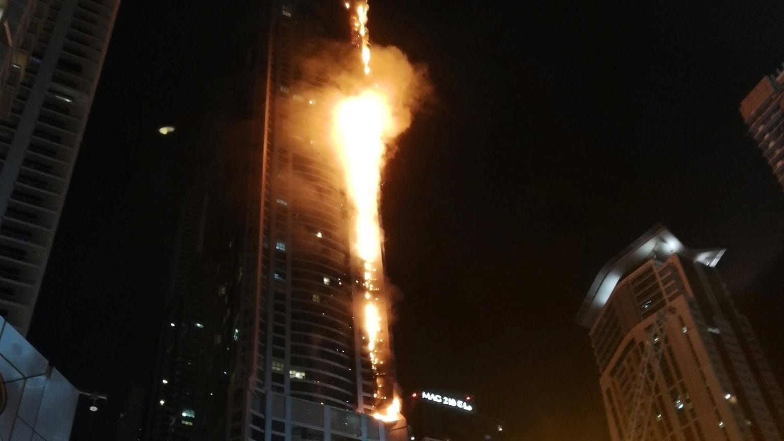 Flammen schossen in der Nacht aus dem Torch Tower in Dubai in den Vereinigten Arabischen Emiraten. Flammen schossen in der Nacht aus dem Torch Tower in Dubai in den Vereinigten Arabischen Emiraten.