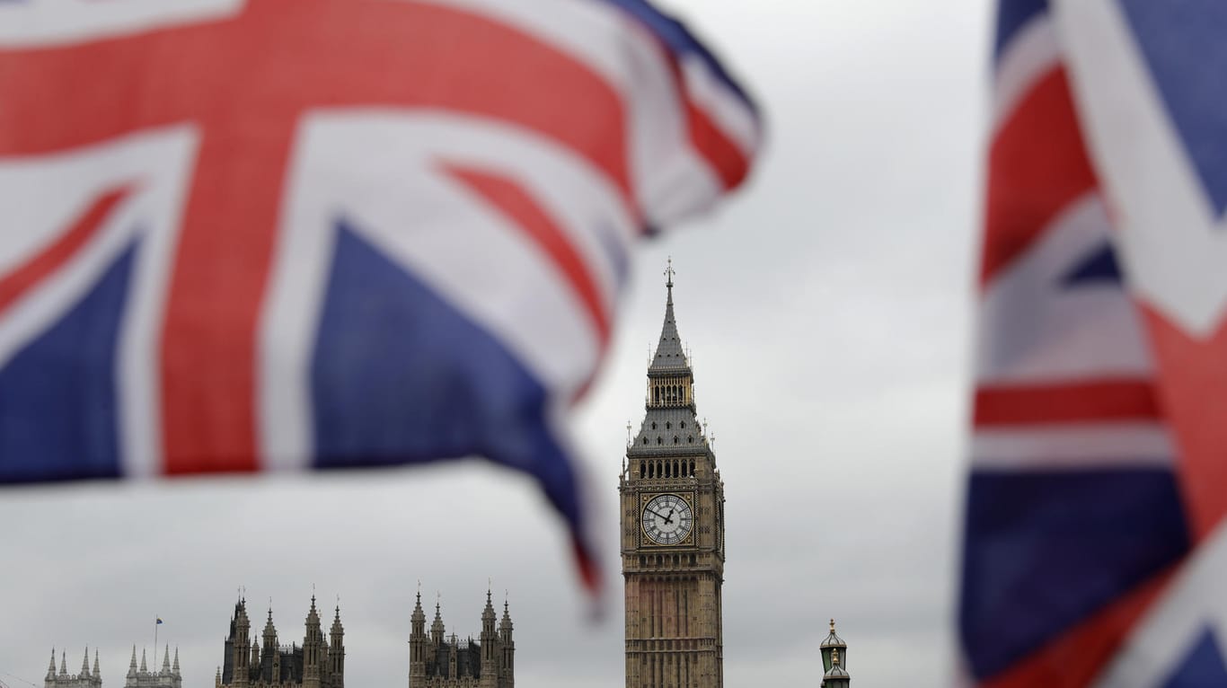 Britische Fähnchen an einem Touristen-Geschäft wehen vor den Houses of Parliament in London.