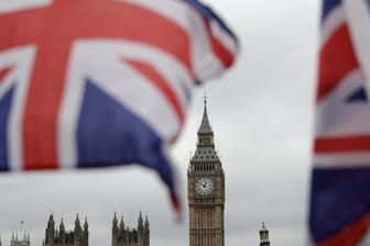 Britische Fähnchen an einem Touristen-Geschäft wehen vor den Houses of Parliament in London.