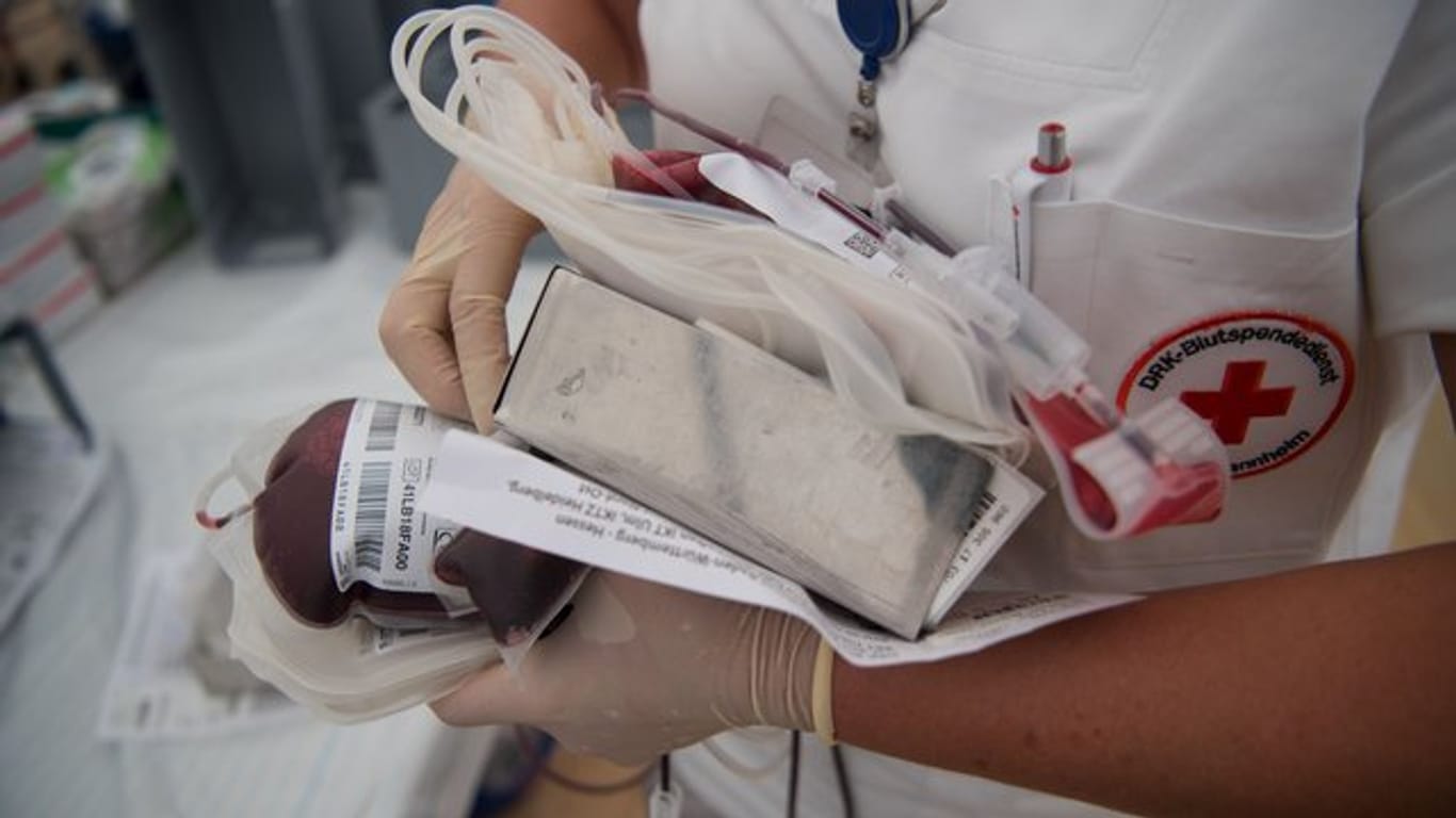 Eine Krankenschwester mit Vollblutbeutel und ein geschlossenes Blutspende-Einwegsystem.
