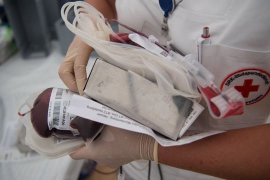 Eine Krankenschwester mit Vollblutbeutel und ein geschlossenes Blutspende-Einwegsystem.