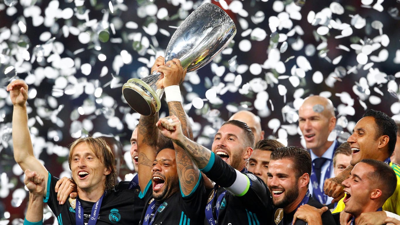Marcelo reckt den Pokal in die Höhe und feiert mit seinen Teamkollegen von Real Madrid den Sieg im Supercup.