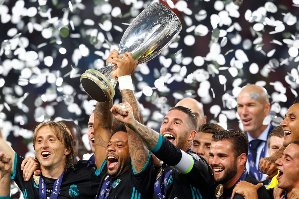 Marcelo reckt den Pokal in die Höhe und feiert mit seinen Teamkollegen von Real Madrid den Sieg im Supercup.