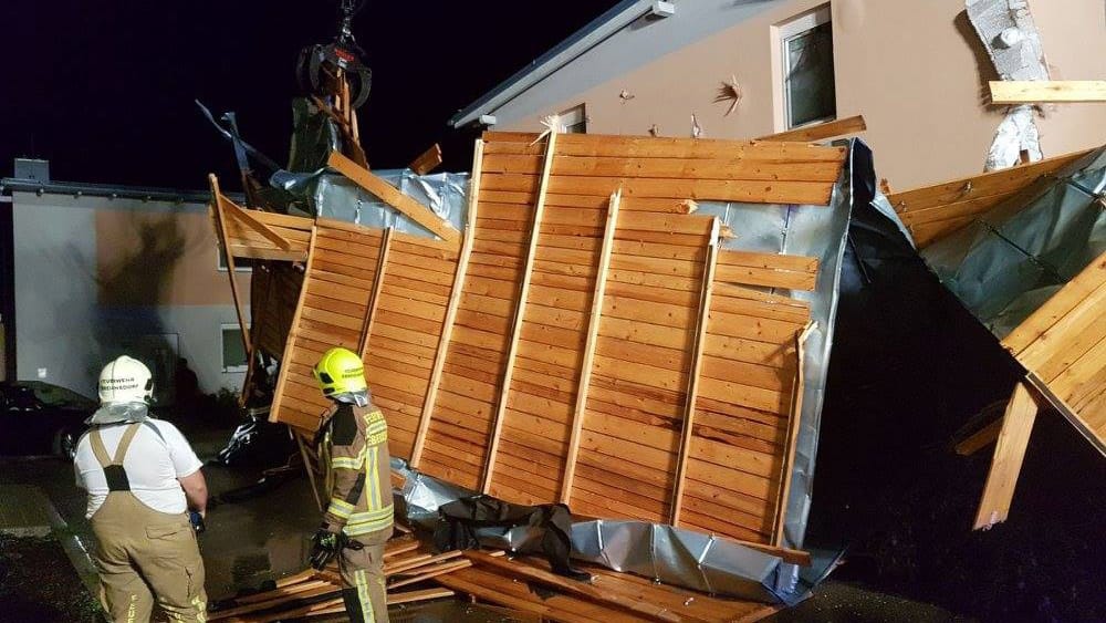 Einsatzkräfte der Feuerwehr räumen in Baden Schäden nach schweren Unwettern auf.