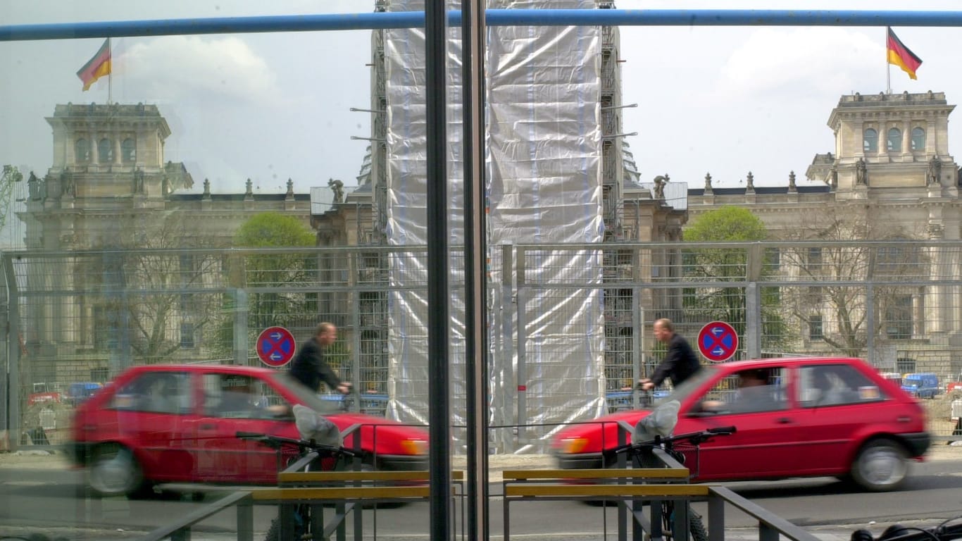 Das Reichstagsgebäude, ein Rad- und ein Autofahrer spiegeln sich im Glas: Am 24. September bestimmen letztere, wer in ersteres einzieht.