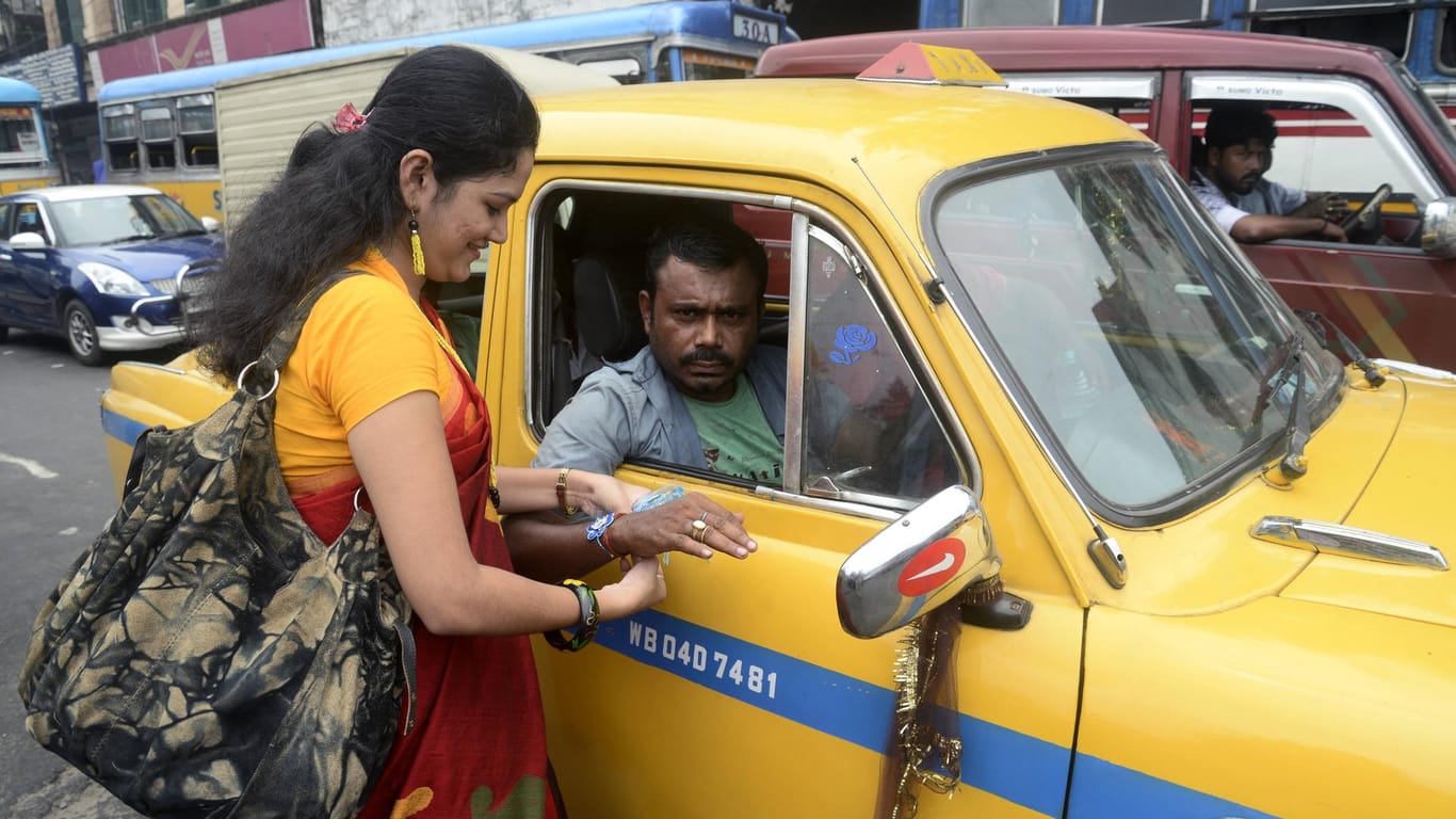 Frau und Taxifahrer: Andere Länder – andere Sitten. Das gilt auch oft beim Taxifahren.