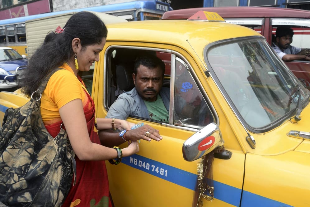 Frau und Taxifahrer: Andere Länder – andere Sitten. Das gilt auch oft beim Taxifahren.