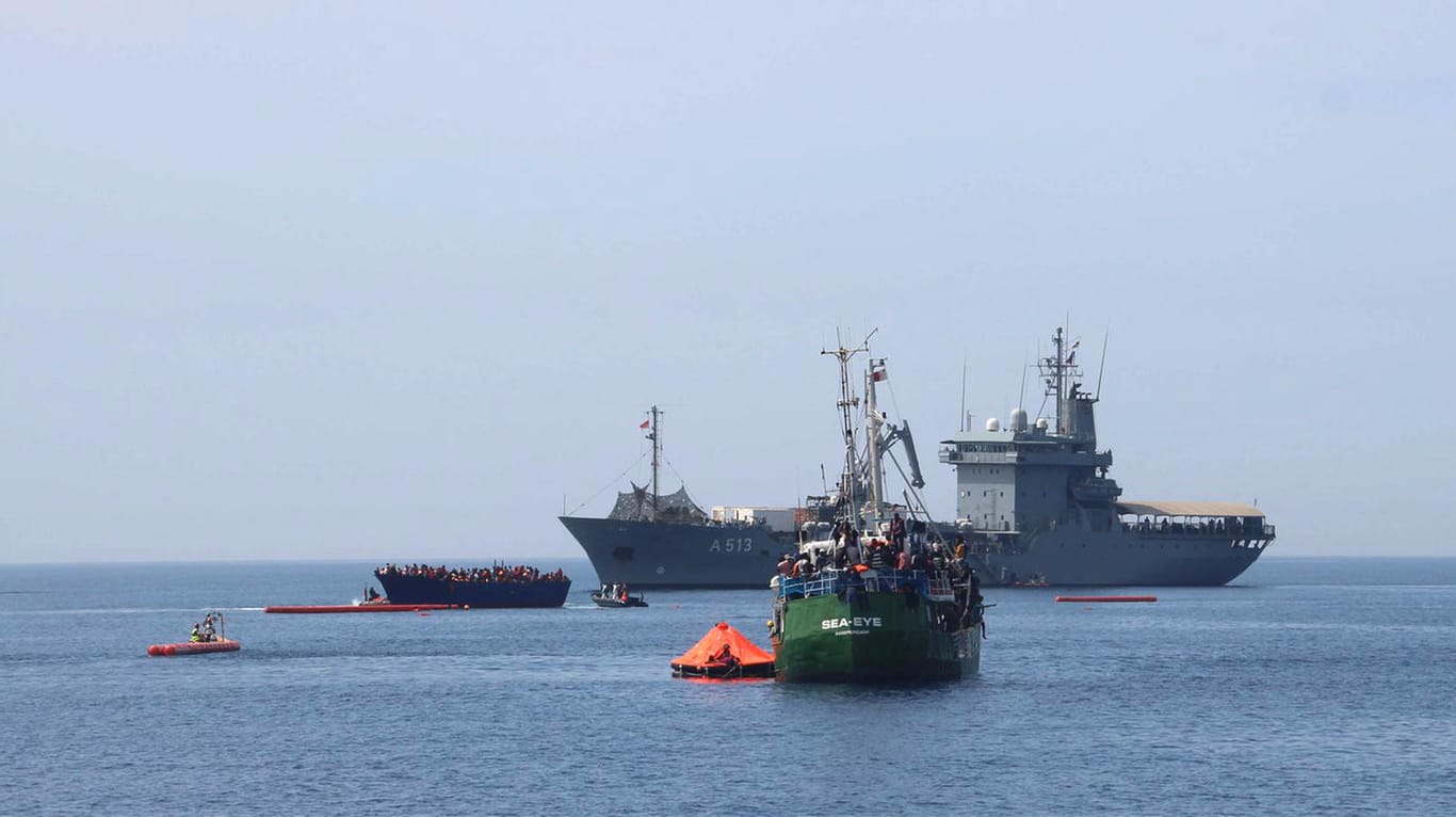 Die "Sea-Eye" und ein deutsches Marineschiff nehmen die Insassen eines überfüllten Migrantenbootes auf.