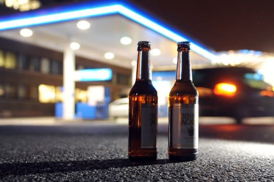 Zwei Bierflaschen vor einer Tankstelle