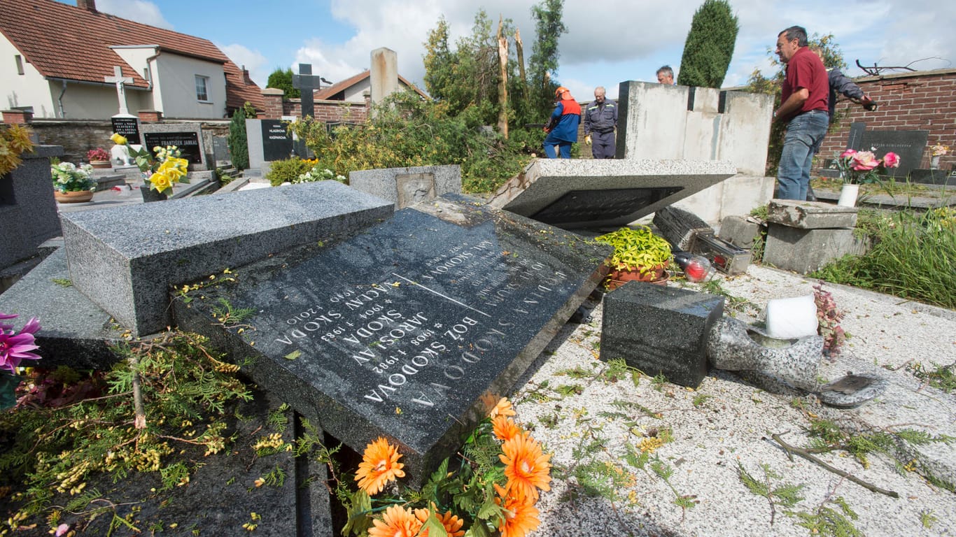 Grabsteine liegen in Bohuslavice (Tschechien) umgestürzt auf Gräbern. Heftige Stürme haben in Polen und Tschechien große Schäden angerichtet.