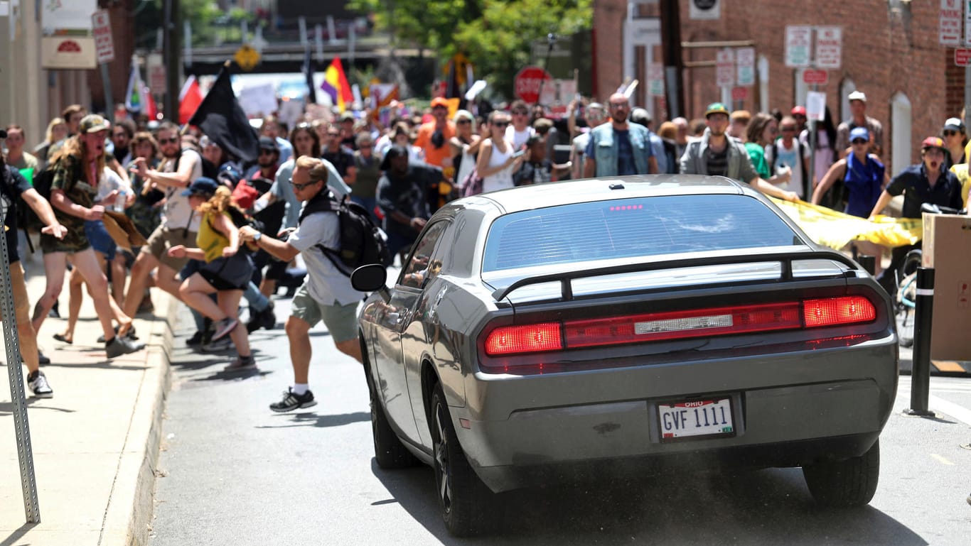 Mit hoher Geschwindigkeit fährt ein Fahrzeug in eine Gruppe von Demonstranten in Charlottesville.