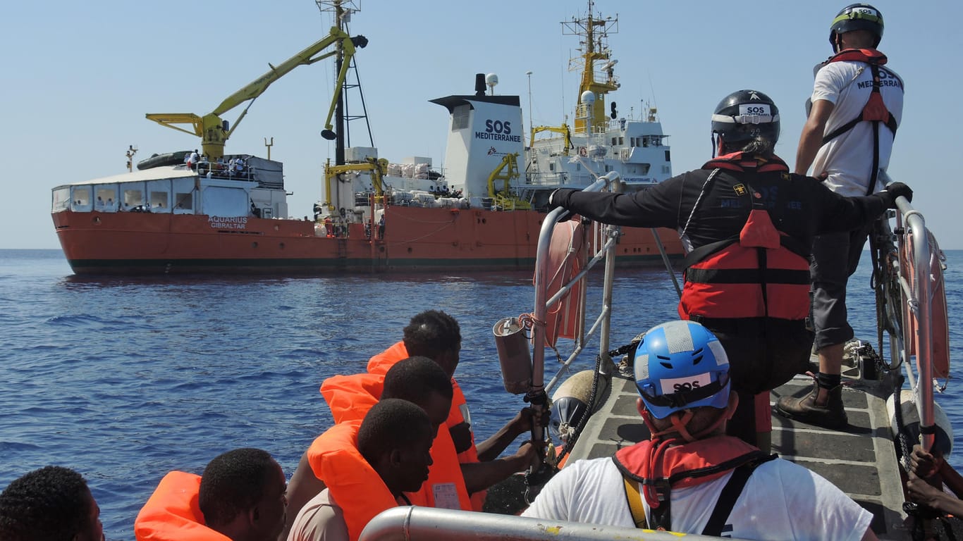 Mitarbeiter von "Ärzte ohne Grenzen" bringen gerettete Migranten zum Schiff "Aquarius".