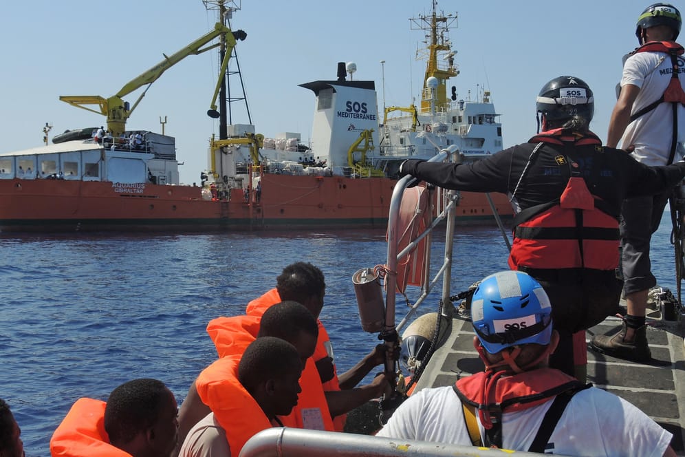 Mitarbeiter von "Ärzte ohne Grenzen" bringen gerettete Migranten zum Schiff "Aquarius".