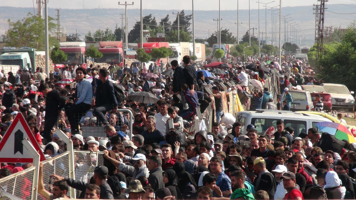 Syrische Flüchtlinge stehen am syrisch-türkischen Grenzübergang in Kilis (Türkei).