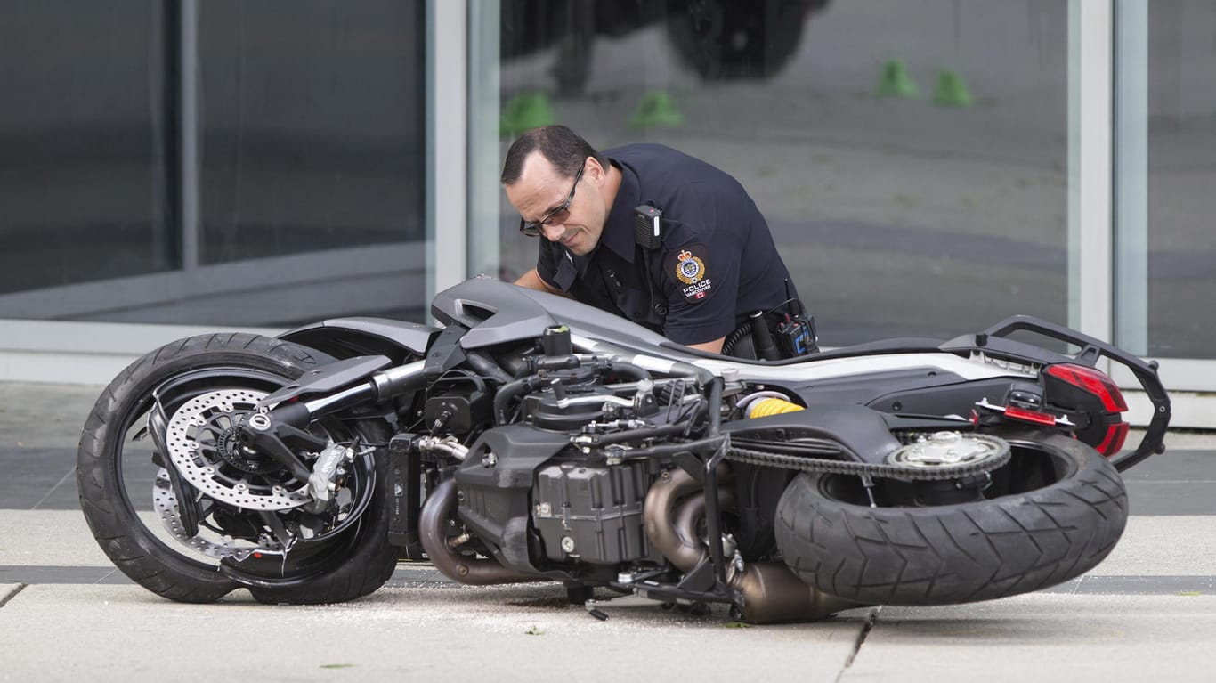 Ein Polizist untersucht das Motorrad der Stuntfrau.