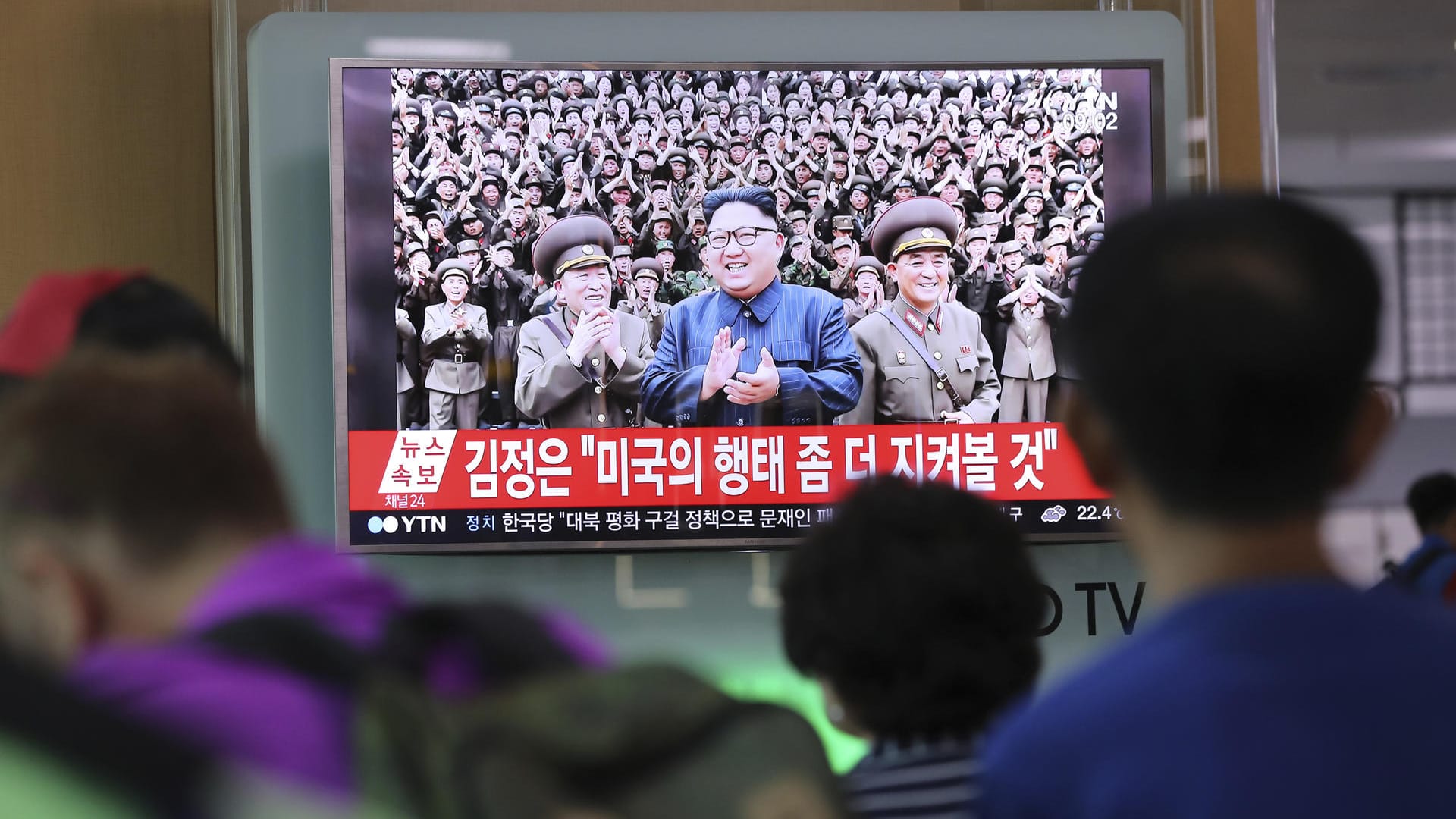 Passagiere schauen im Bahnhof von Seoul die Übertragung eines südkoreanischen Fernsehsenders an.