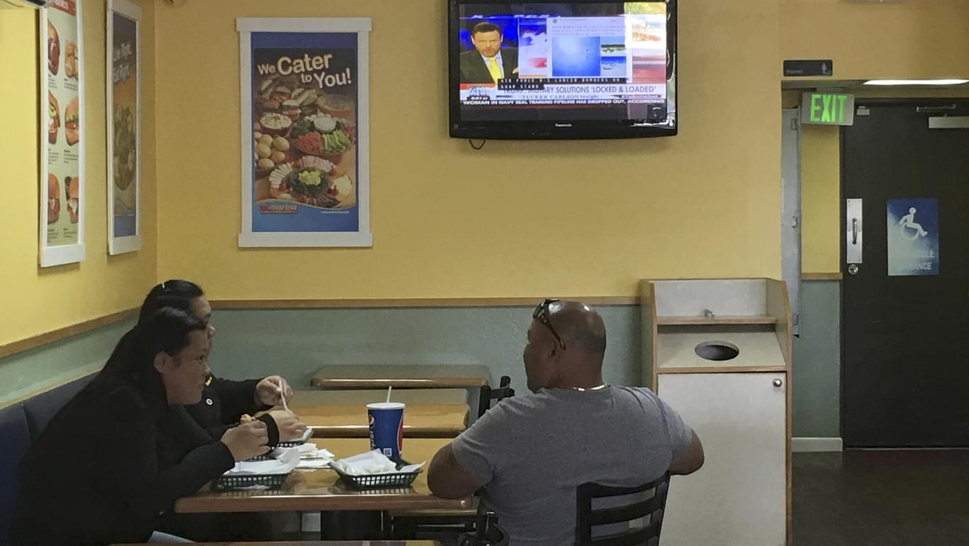Bewohner Guams verfolgen in einem Imbiss eine Nachrichtensendung.