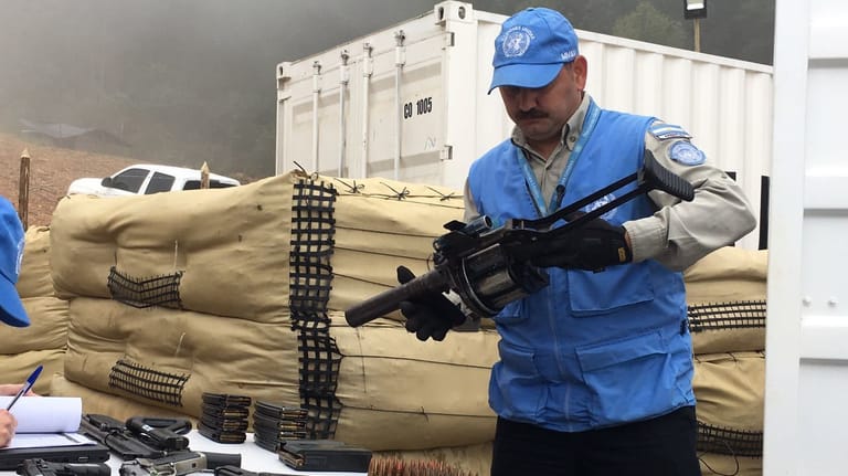 Ein UN-Mitarbeiter beim Einsammeln von Waffen der kolumbianischen Farc-Rebellen.