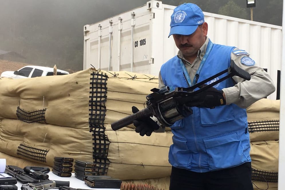Ein UN-Mitarbeiter beim Einsammeln von Waffen der kolumbianischen Farc-Rebellen.