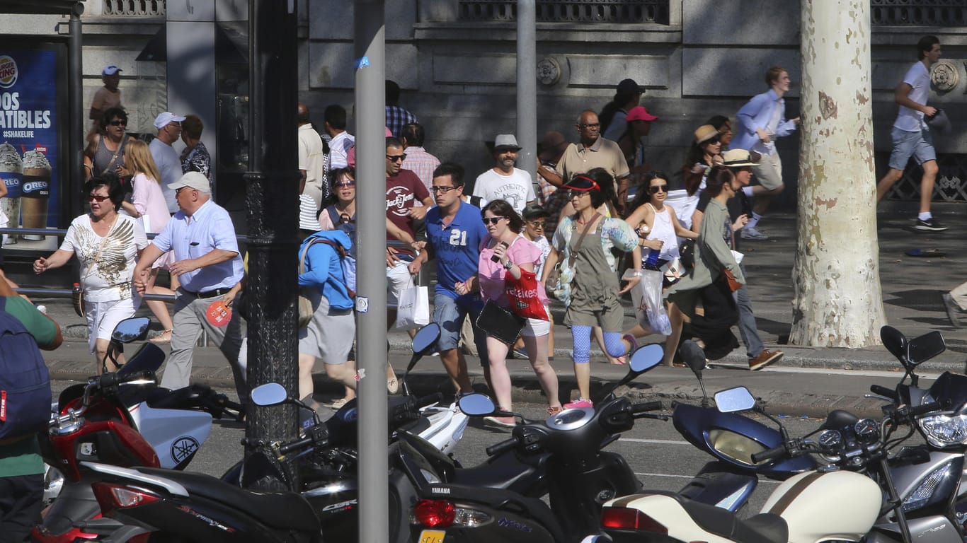 Passanten rennen in Panik über eine Straße in Barcelona.