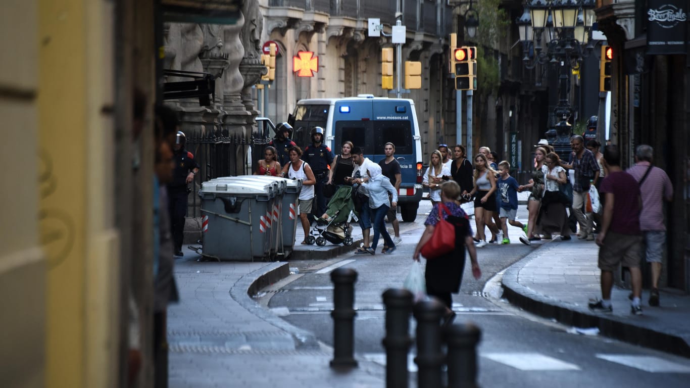 Passanten flüchten in der Innenstadt von Barcelona in eine Seitenstraße.
