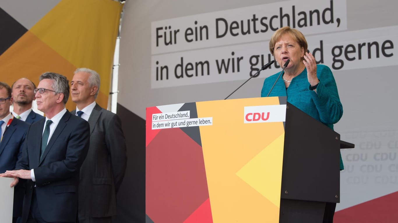 Bundeskanzlerin Angela Merkel (CDU) spricht bei einem Wahlkampfauftritt in Annaberg-Buchholz (Sachsen) neben Bundesinnenminister Thomas de Maizière (l) und Sachsens Ministerpräsident Stanislaw Tillich (2.v.l., alle CDU).