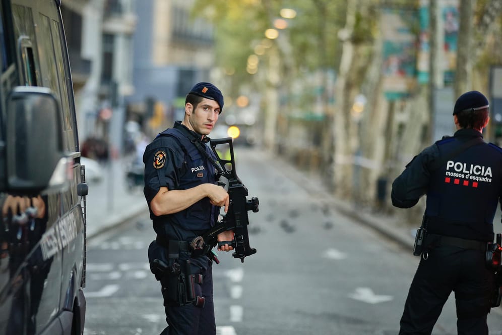 Polizisten sichern am 18.08.2017 den Bereich auf der Flaniermeile Las Ramblas in Barcelona (Spanien), auf dem Tags zuvor ein Lieferwagen in eine Menschenmenge gefahren war.