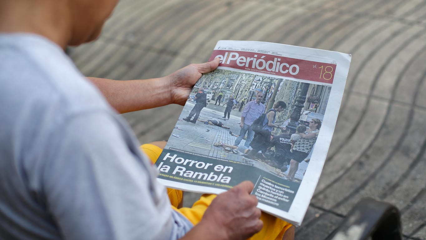 Ein Mann liest auf der Promenade La Rambla, auf der es am Donnerstag zum tödlichen Anschlag kam, eine Zeitung.