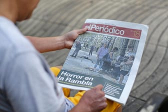 Ein Mann liest auf der Promenade La Rambla, auf der es am Donnerstag zum tödlichen Anschlag kam, eine Zeitung.