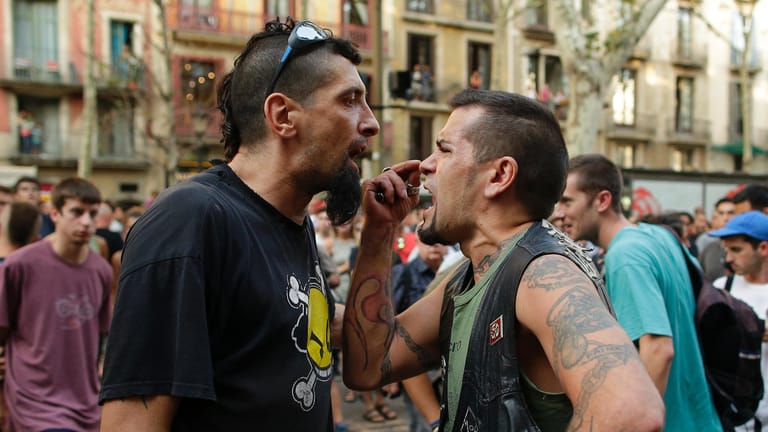 Ein linker und ein rechter Demonstrant schreien sich in Barcelona an.