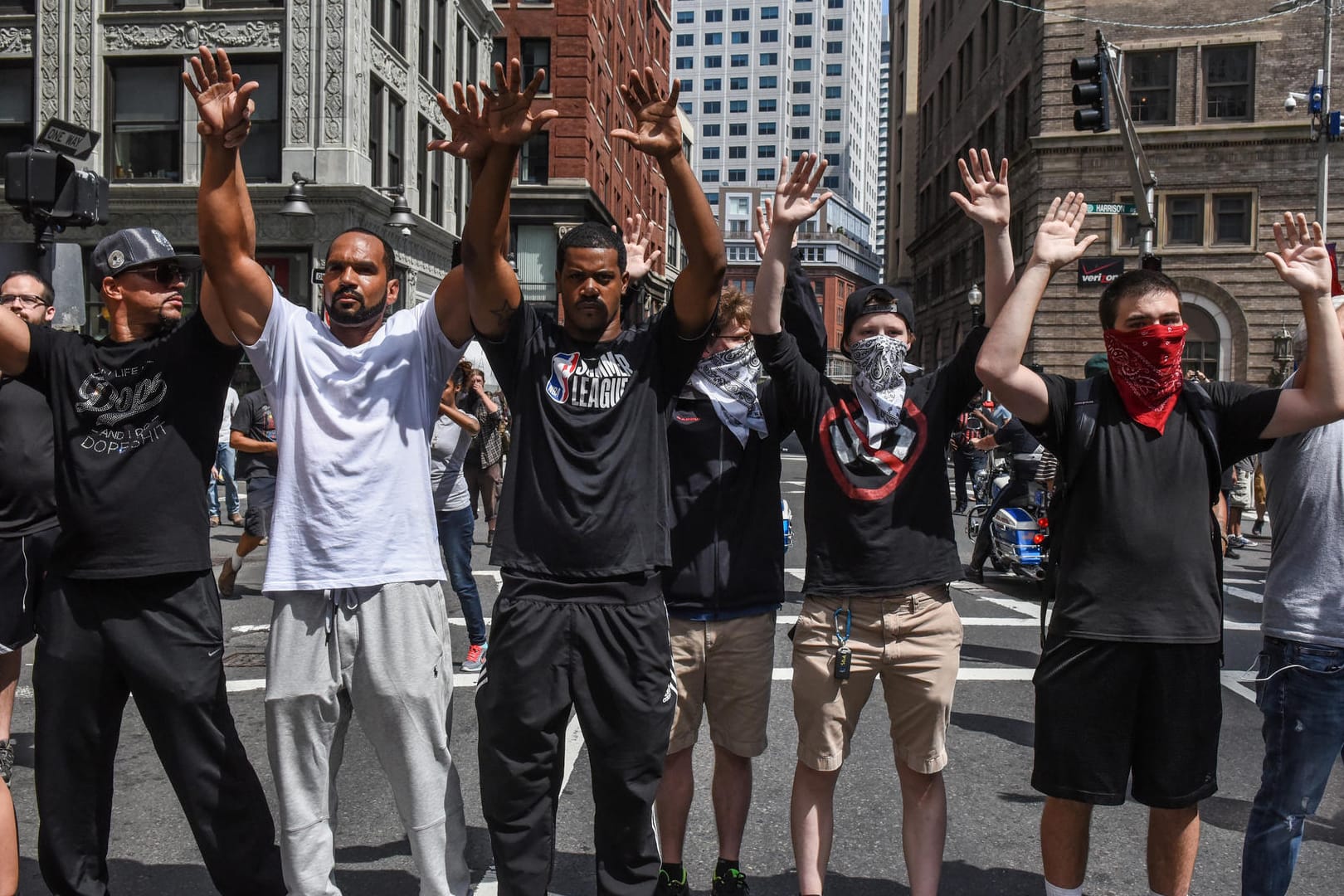 Gegendemonstranten blockieren mit hochgehaltenen Armen eine Straße in Boston.