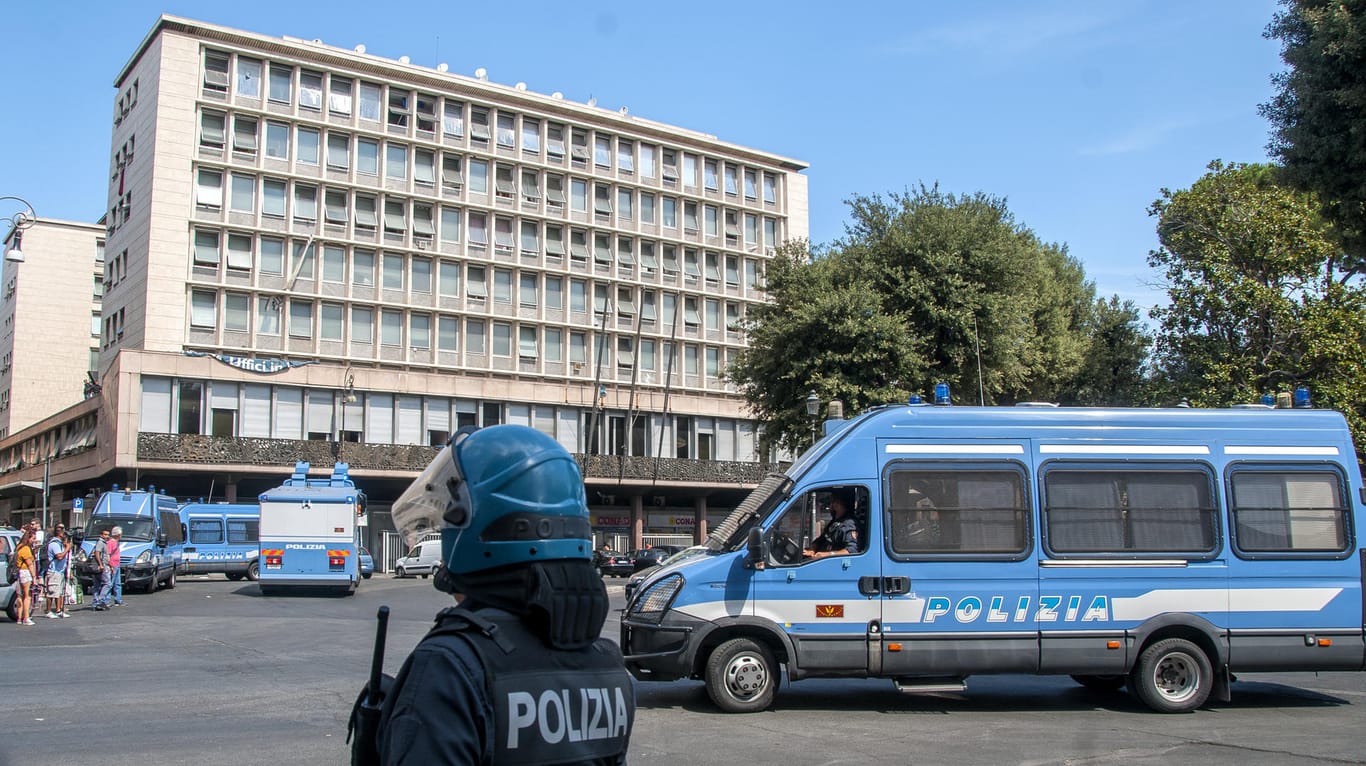 Ein Polizist steht in Rom vor einem Haus, das von fast 1000 Migranten besetzt und am frühen Morgen geräumt worden war.