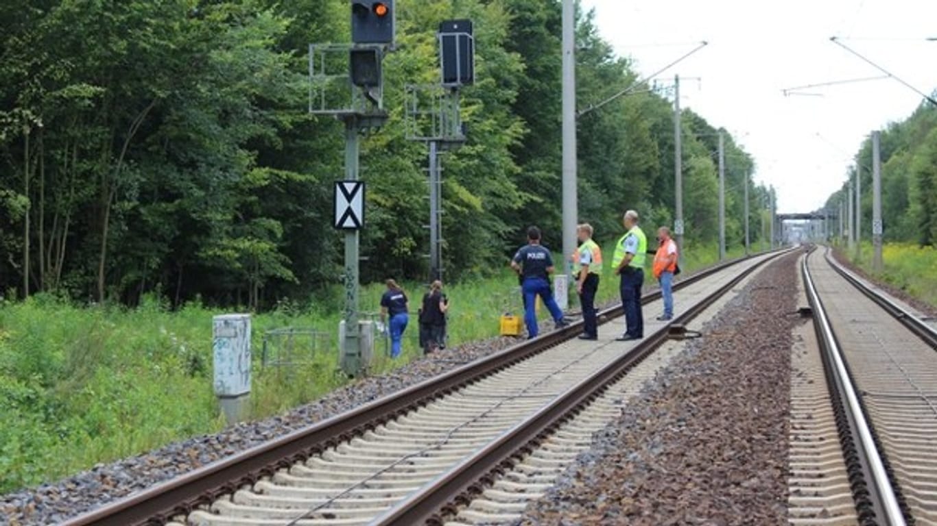 Mitarbeiter der Bahn und der Polizei untersuchen eine Signalanlage bei Berlin. Unbekannte hatten sie in Brand gesetzt.