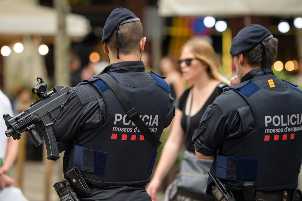 Schwer bewaffnete Polizisten stehen an der Flaniermeile Las Ramblas in Barcelona (Spanien).