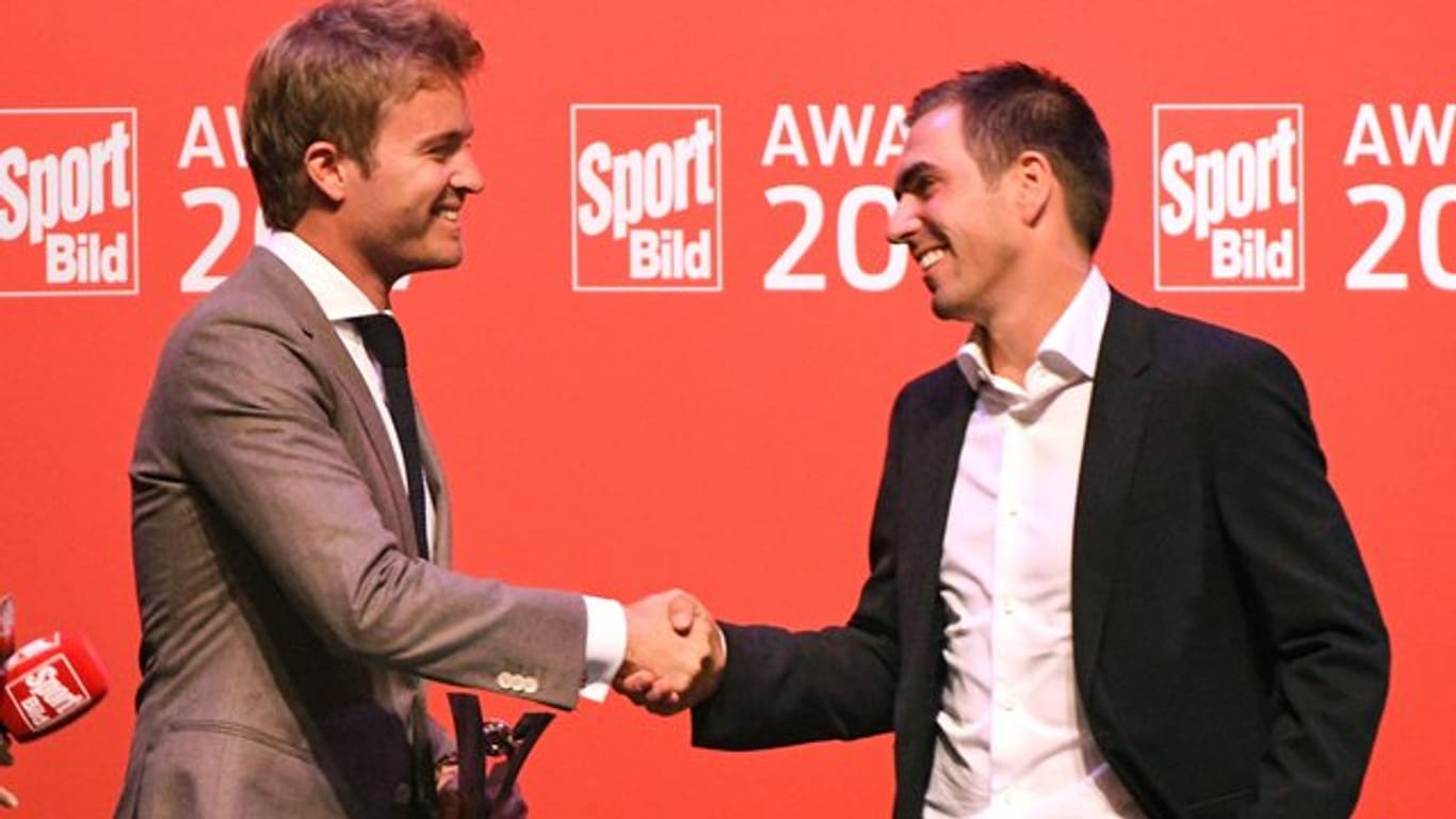 Weltmeister unter sich: Formel-1-Weltmeister Nico Rosberg (l) ehrt Fußball-Weltmeister Philipp Lahm.