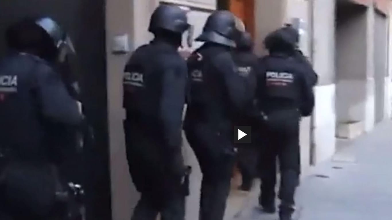 Einsatzkräfte der katalanischen Polizei stürmen bei einem Antio-Terroreinsatz eine Wohnung.