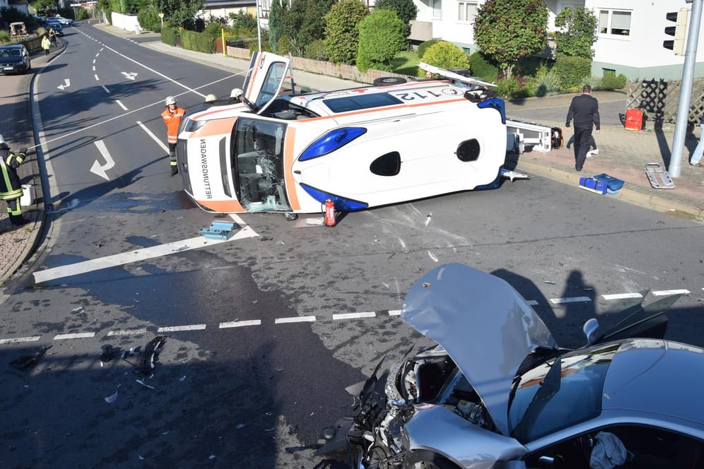 Rettungskräfte stehen um den verunfallten Rettungswagen.