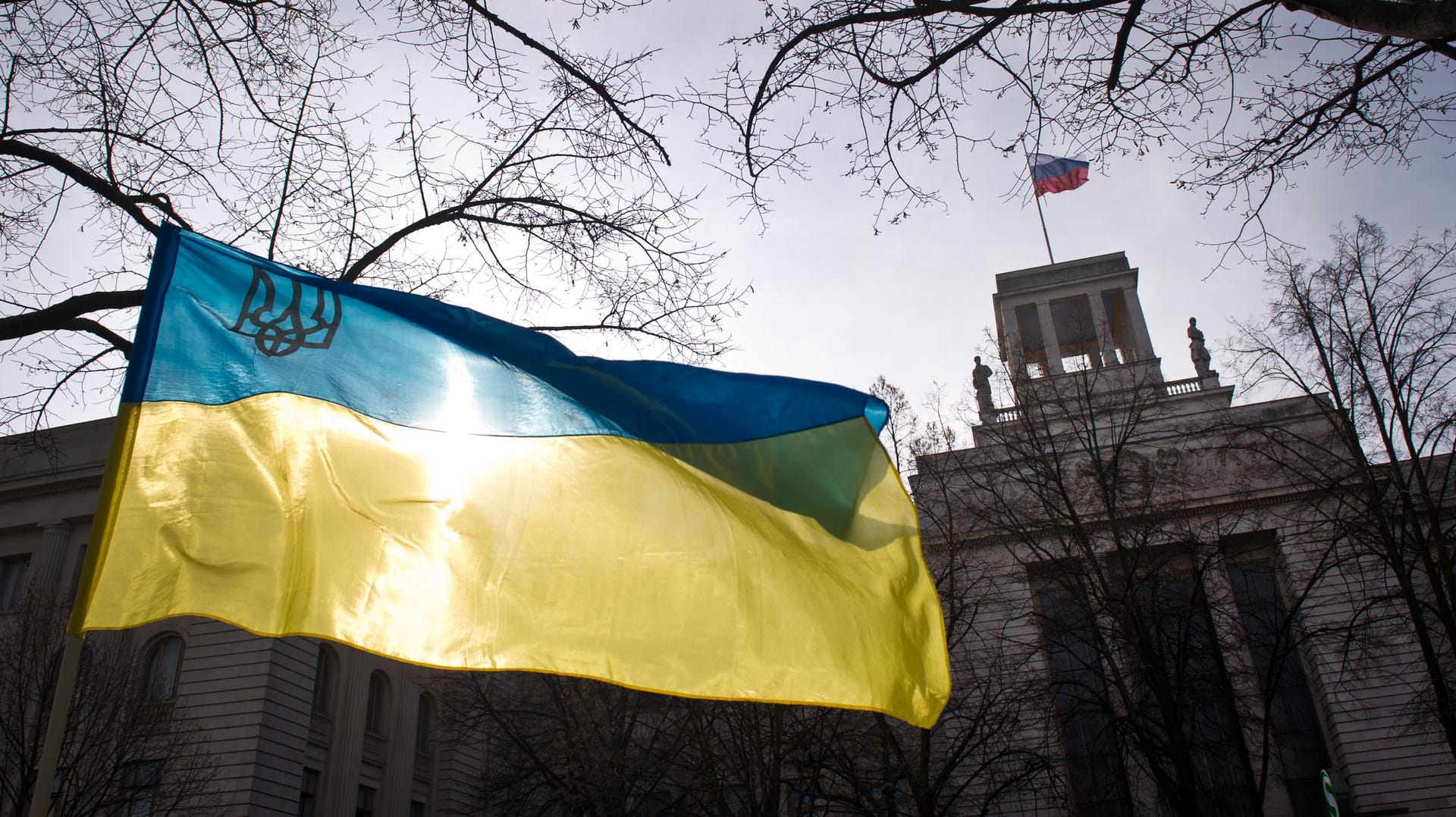 Die ukrainische Flagge ist in Berlin am Rande einer Demonstration vor der russischen Botschaft zu sehen.