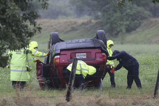 Rettungskräfte inspizieren im texanischen San Antonio ein von Hurrikan "Harvey" umgeworfenes Auto.