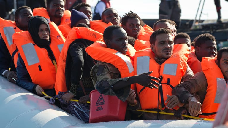 Migranten werden auf dem Mittelmeer von Seenotrettern aufgenommen.