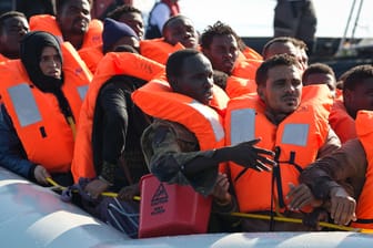 Migranten werden auf dem Mittelmeer von Seenotrettern aufgenommen.