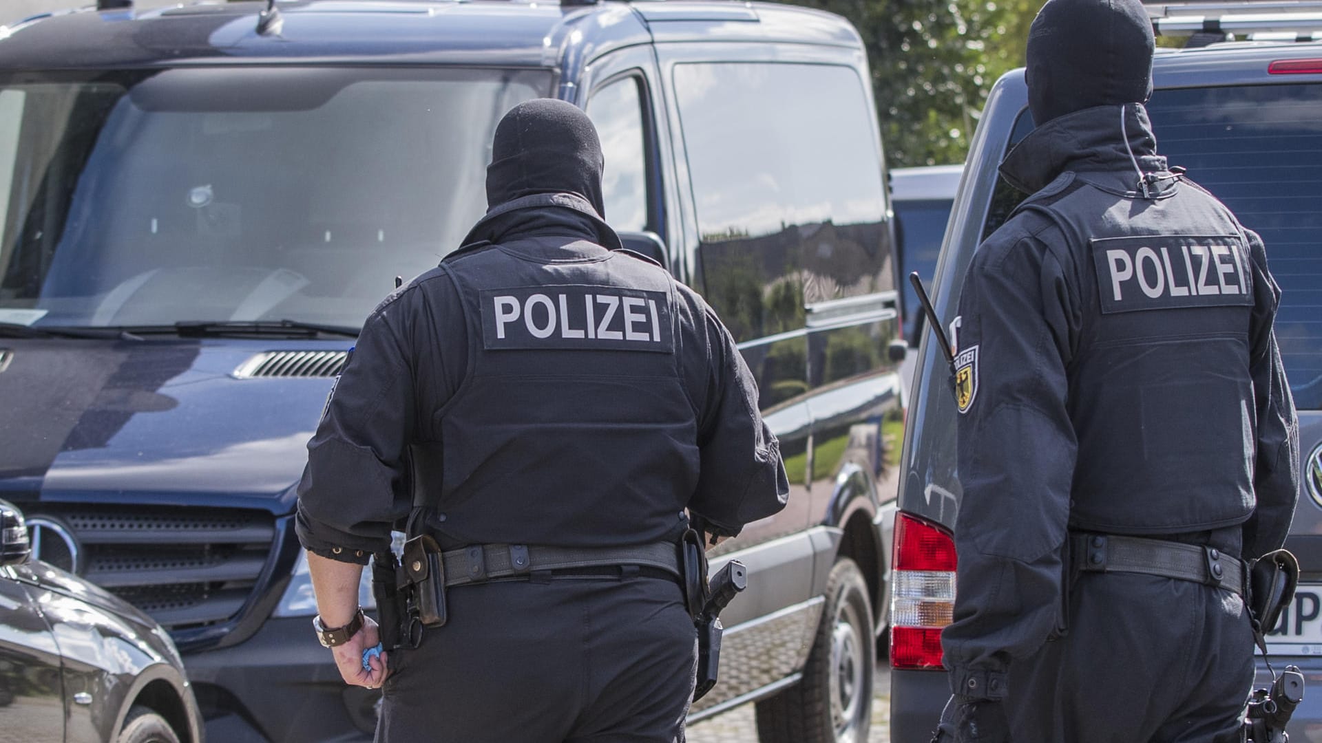 Polizisten einer Spezialeinheit durchsuchen ein Grundstück in Banzkow.