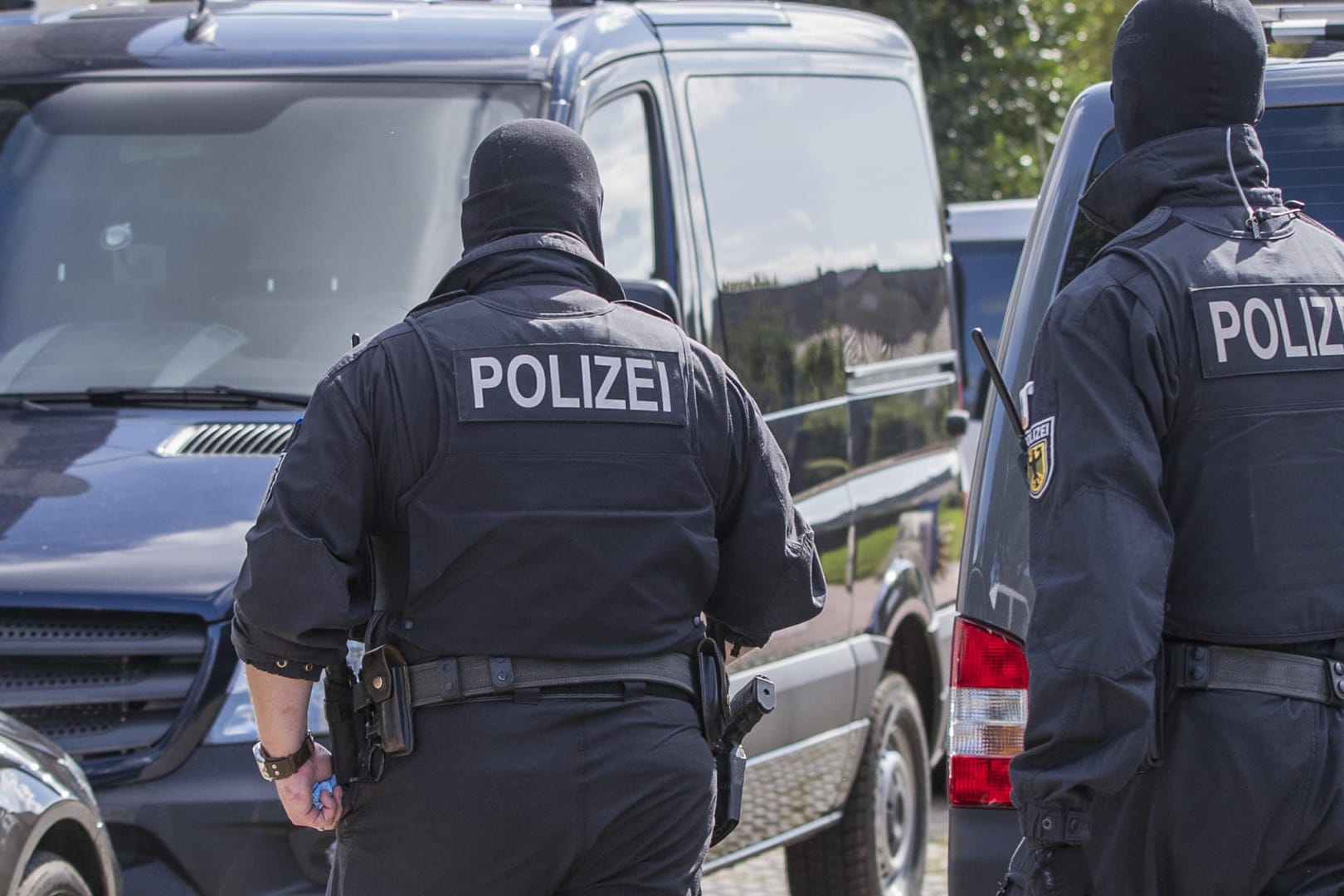 Polizisten einer Spezialeinheit durchsuchen ein Grundstück in Banzkow.