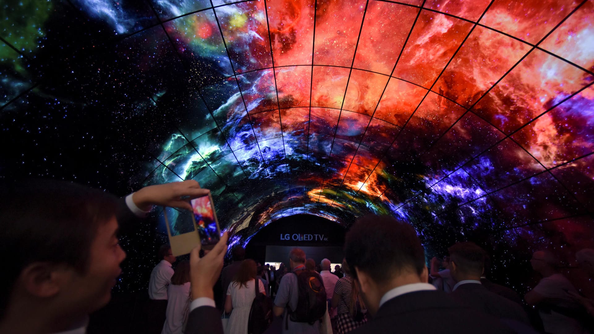 Besucher der IFA in einem Tunnel aus Curved-TVs.