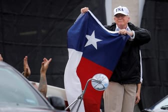 US-Präsident Trump hält in Corpus Christi eine Fahne des US-Staates Texas in den Händen, während ihm seine Anhänger zujubeln.