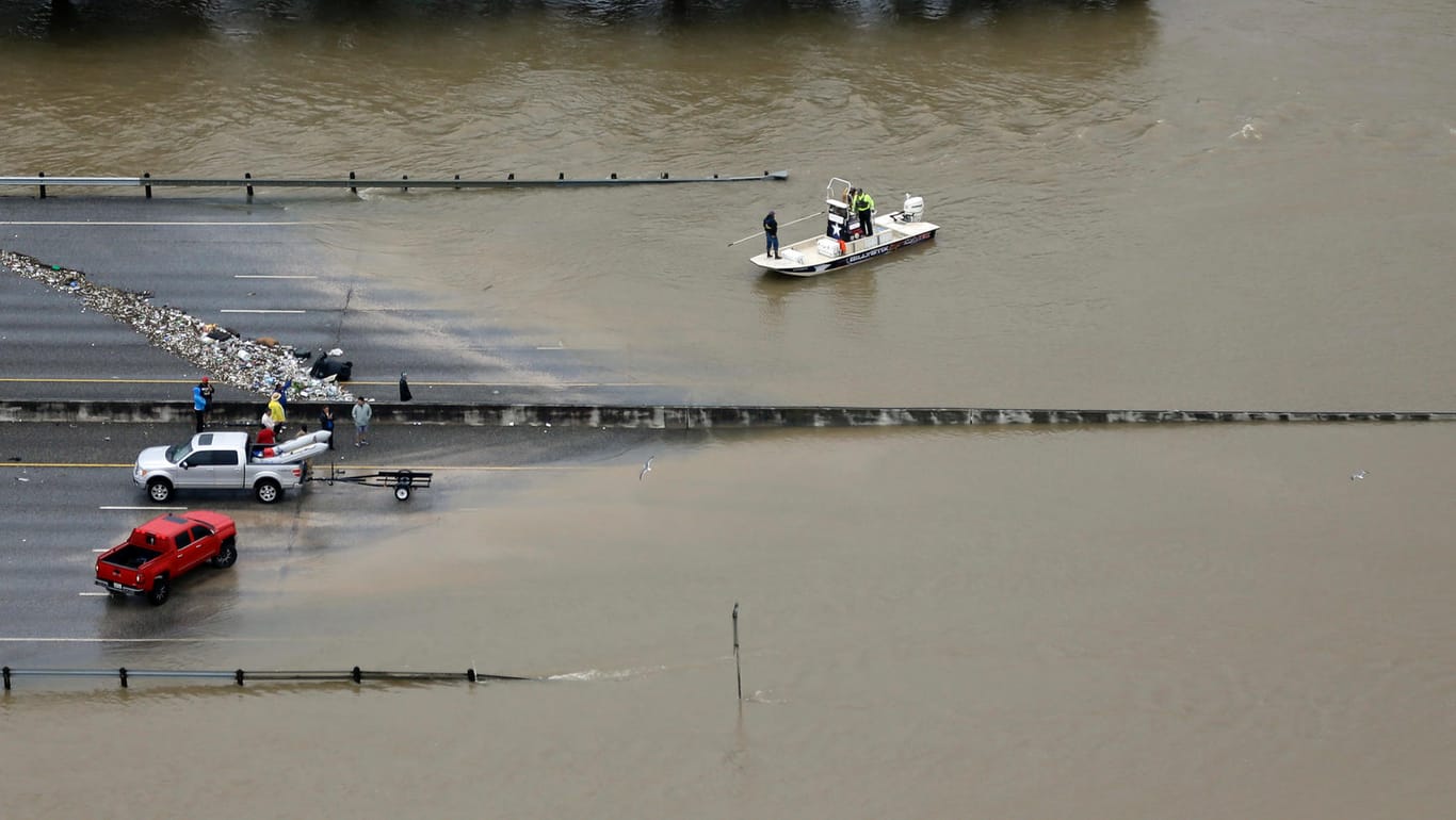 Helfer navigieren mit einem Boot auf einer überschwemmten Autobahn in Houston.